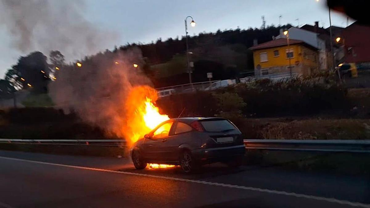 El coche en llamas en el arcén.