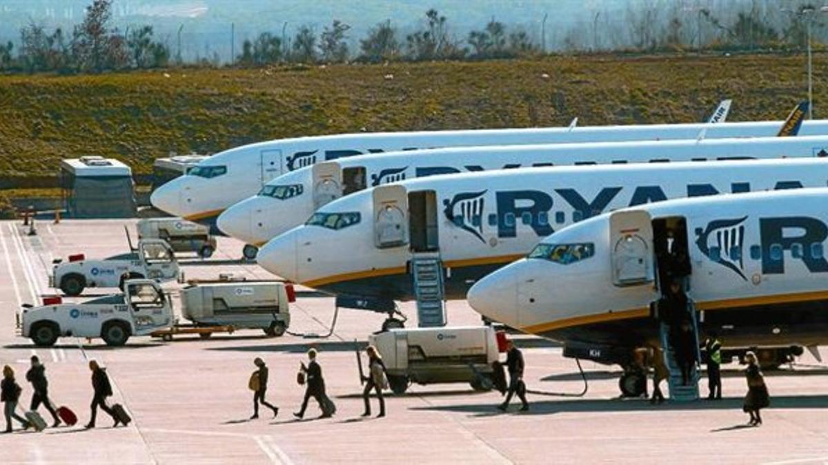 Un grupo de pasajeros baja deun avión de Ryanair en Girona.