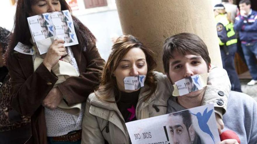 Vecinos de Cudillero protestan durante el Pleno que aprobó la designación de Fernández como alcalde (en la fotografía de los carteles que portan), el pasado mes de marzo.