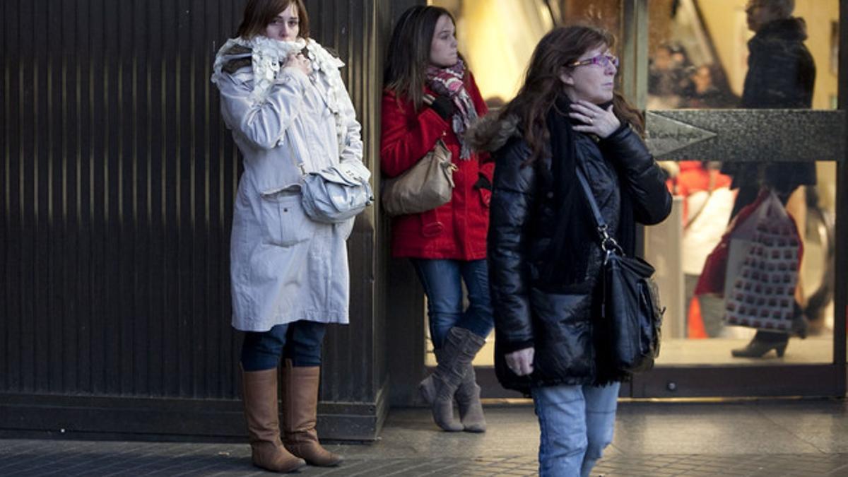 Varias mujeres con bufandas a las puertas del Corte Inglés de la plaza de Catalunya de Barcelona.