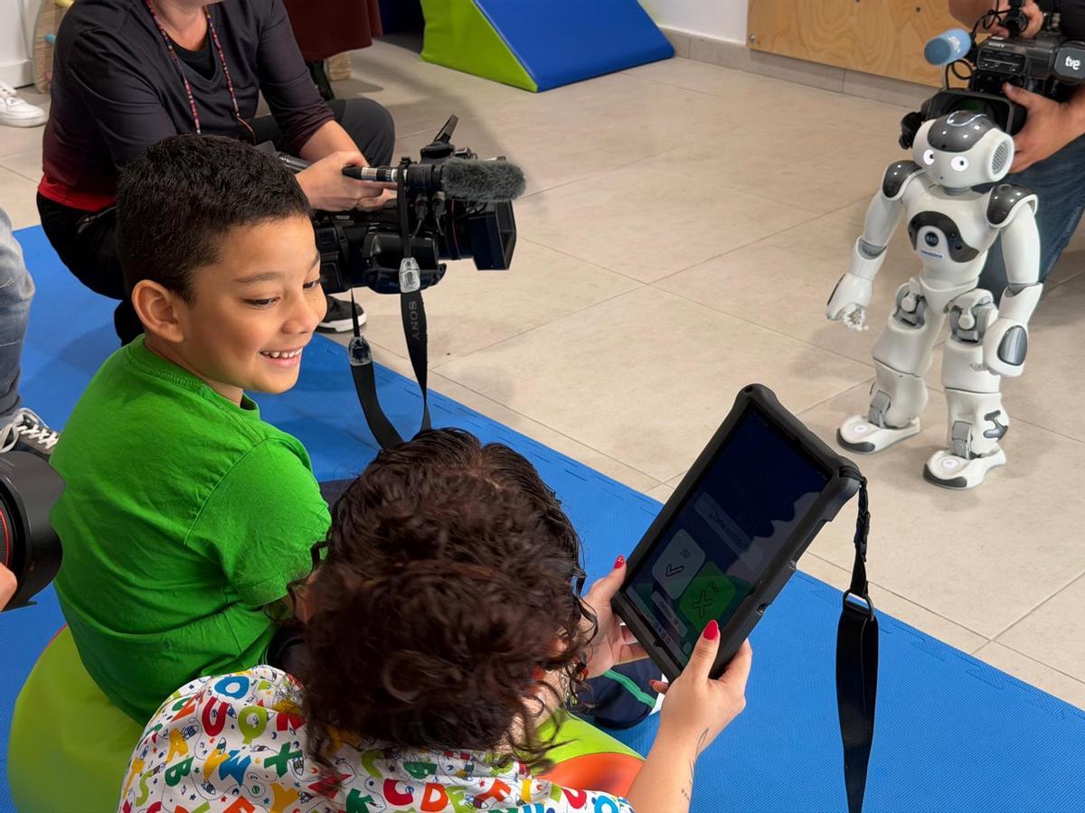Liam Gamboa, de seis años, durante una sesión con ‘Juani’, el nuevo robot que CAIT de San Juan de Dios ha incorporado en sus terapias con niños.
