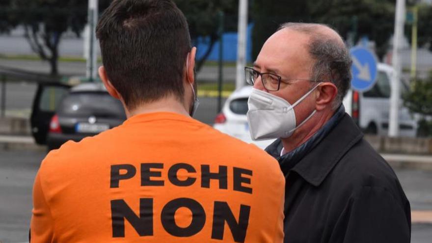 Un trabajador de Alu Ibérica, con el lema ‘peche non’, a las puertas de la fábrica. |   // VÍCTOR ECHAVE