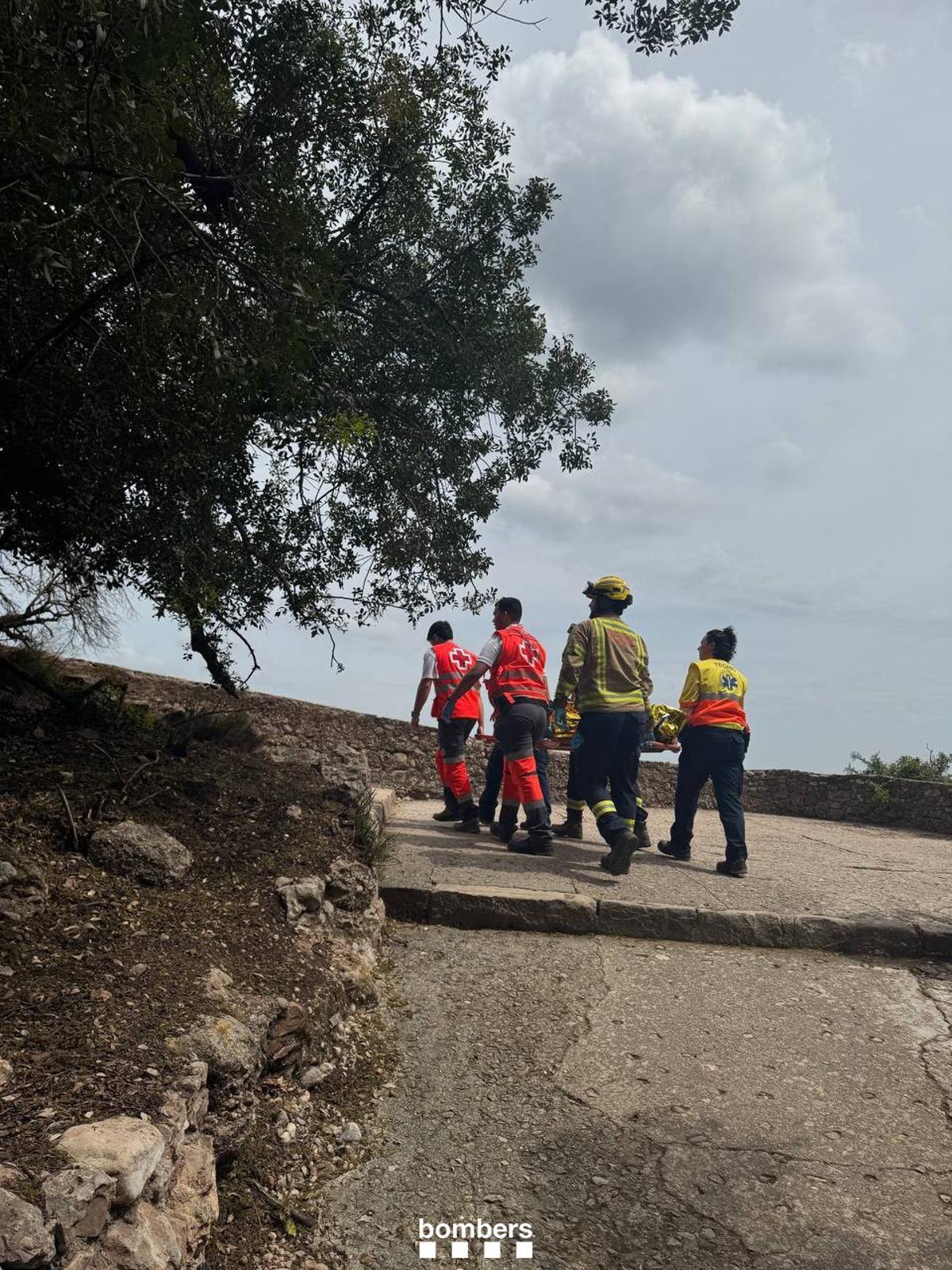 Els equips d'emergència traslladen la dona fins la zona del Monestir