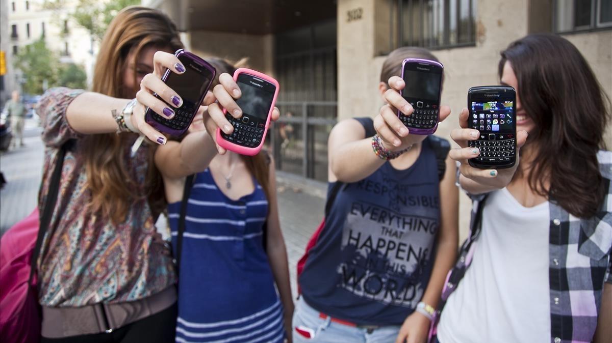 Tres adolescentes muestran sus teléfonos, en una imagen del 2011. Tres adolescentes muestran sus teléfonos, en una imagen del 2011.