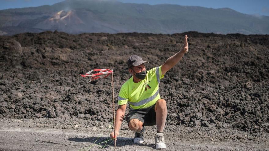 Un operario marcando el trazado de una carretera afectada por las coladas de lava procedentes de la erupción volcánica de La Palma . | | ANDRÉS GUTIÉRREZ