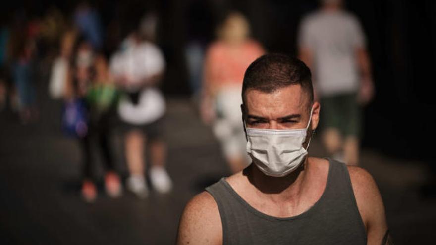 Un joven pasea por las calles de Santa Cruz cumpliendo la normativa del uso de la mascarilla.