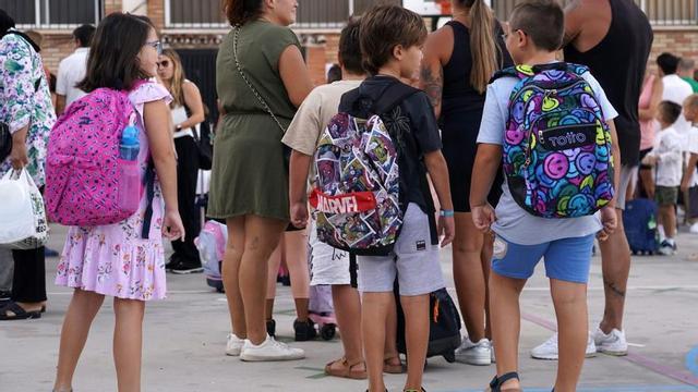Familias con sus hijos en la puerta de un centro educativo público de Málaga en un inicio de curso escolar. | ÁLEX ZEA / EFE