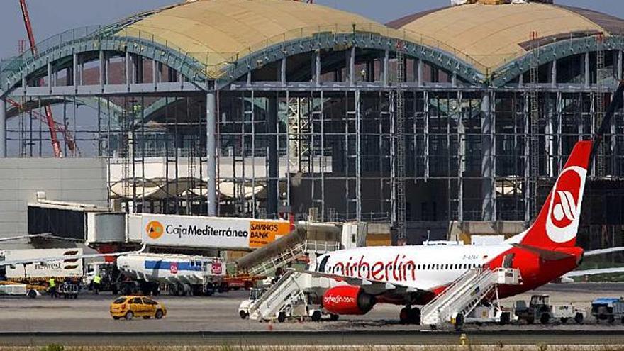 Un avión de Air Berlin espera pasajeros frente el edificio en obras de la nueva terminal.