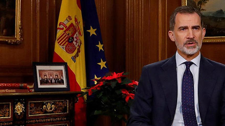 El Rey, con una foto de la familia y un ejemplar de la Constitución.