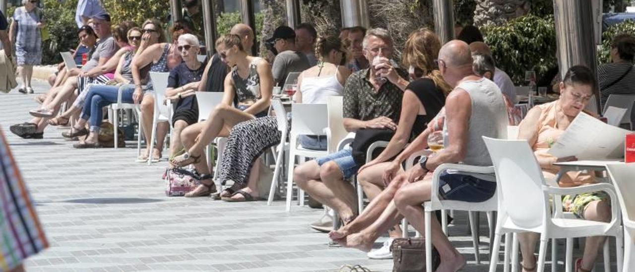 Turistas en una terraza del paseo de Gómiz en la alicantina playa del Postiguet.