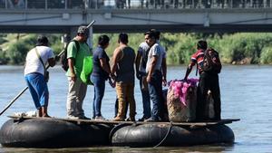 Un grupo de inmigrantes cruza el río Suchiate en unos neumáticos.