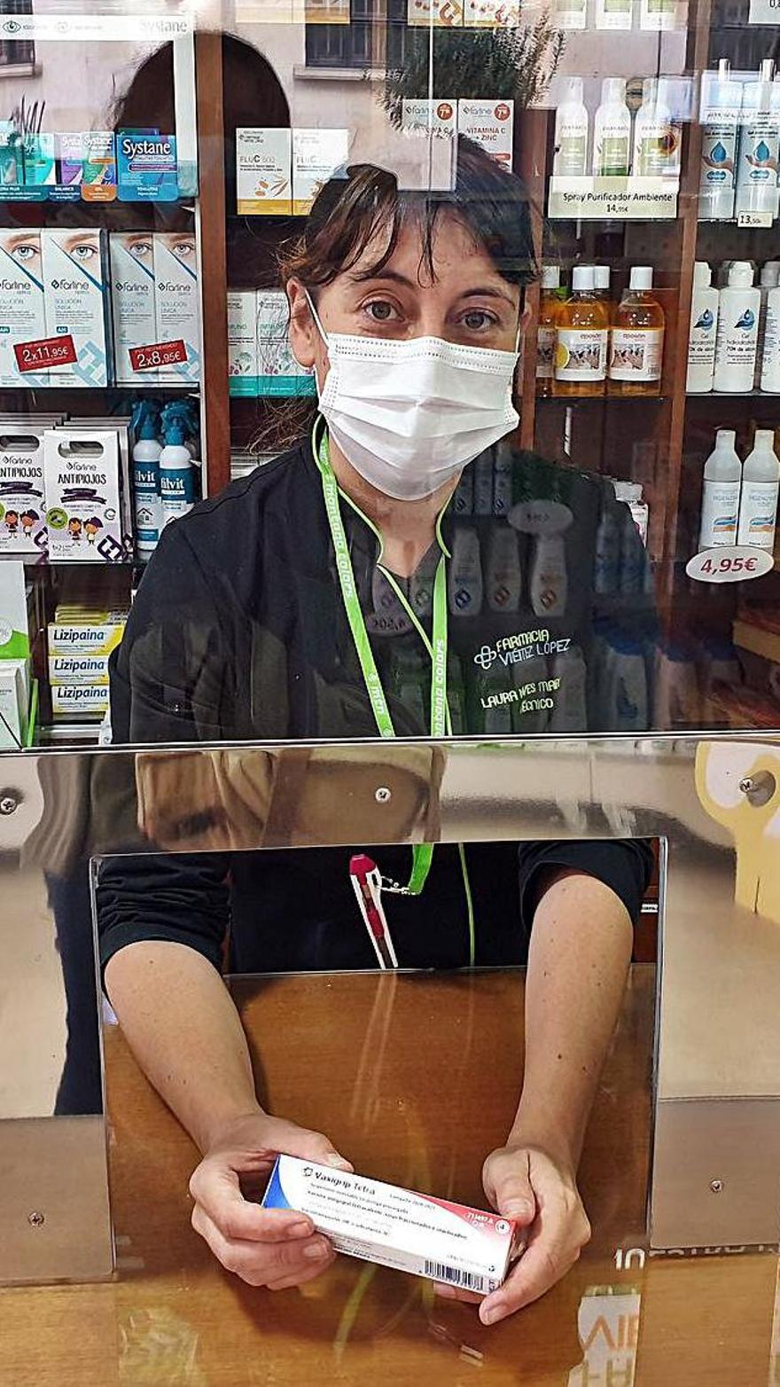 Una boticaria muestra una dosis de vacuna de la gripe en la Farmacia Viéitez López.