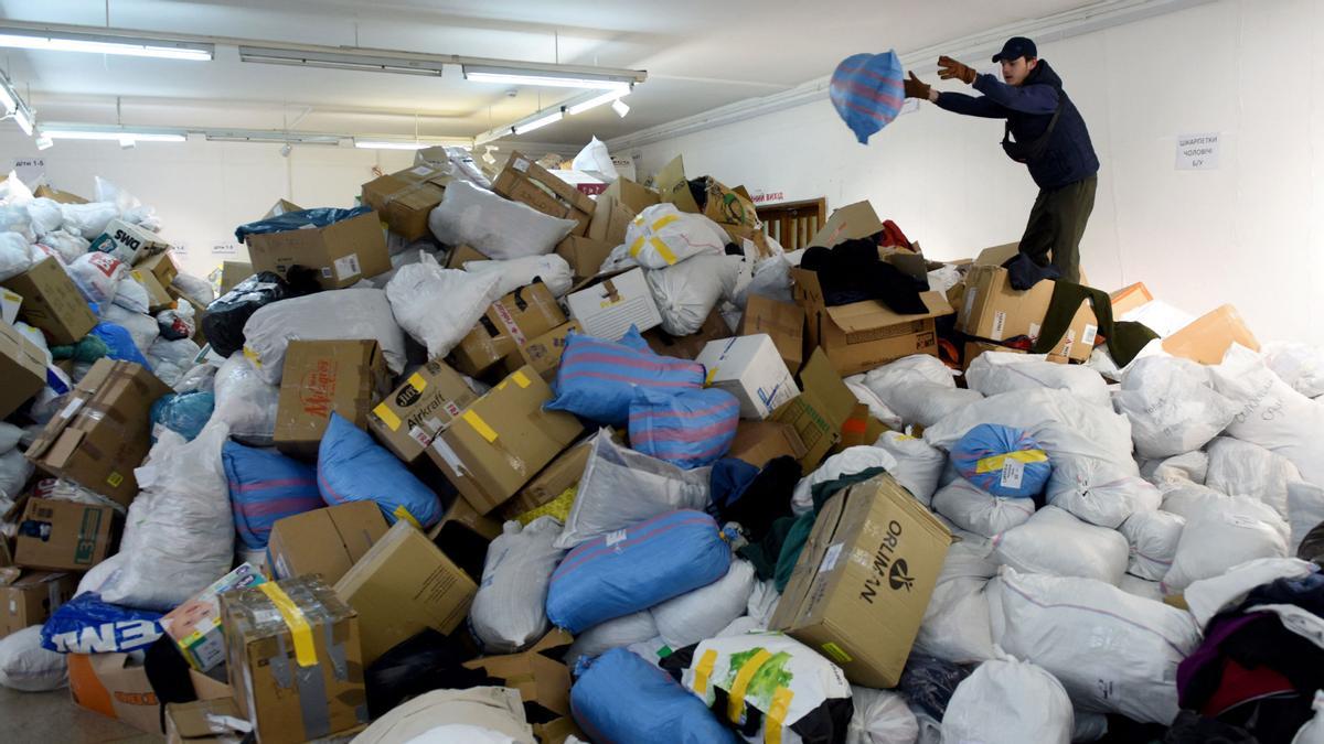 Un voluntario apila bolsas de ropa procedentes de ayuda humanitaria para los civiles evacuados de la ciudad de Lviv en Ucrania