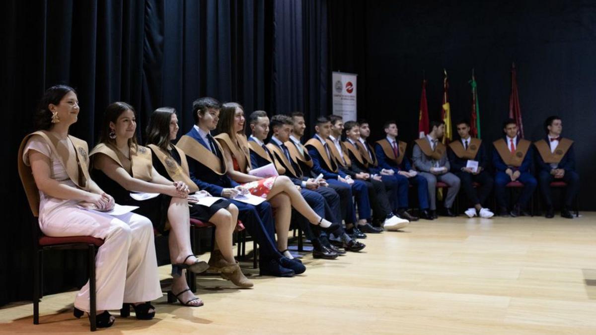 Parte de los recién graduados, sentados con sus becas. | Ana Burrieza