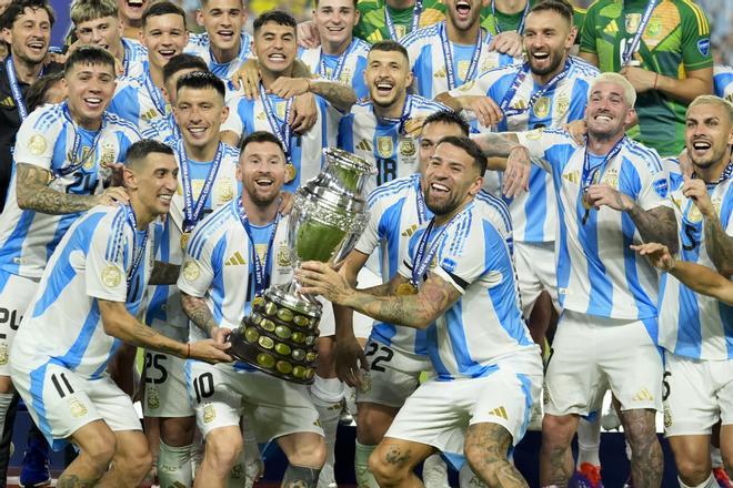 Argentina players Angel di Maria, left, Lionel Messi, second from left, and Nicolas Otamendi, third from left, celebrate with the trophy after defeating Colombia in the Copa America final soccer match in Miami Gardens, Fla., Monday, July 15, 2024. (AP Photo/Rebecca Blackwell) / EDITORIAL USE ONLY/ONLY ITALY AND SPAIN