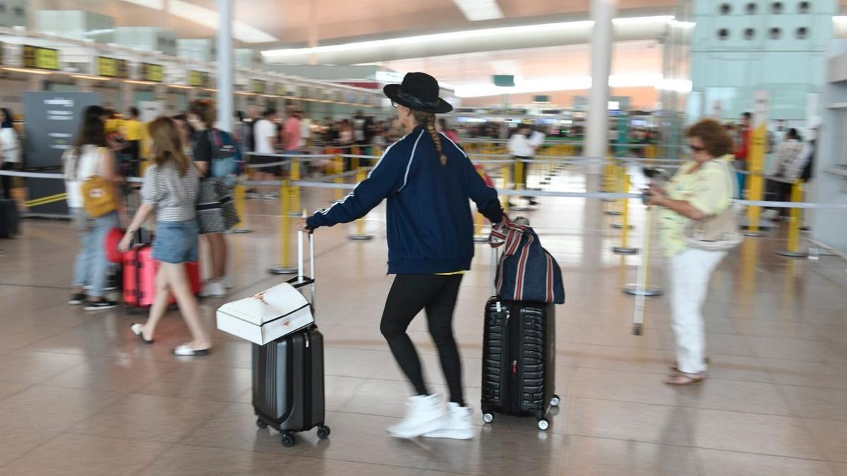 Pasajeros, en el aeropuerto de Barcelona-El Prat, en el primer día de huelga del personal de tierra de Iberia.