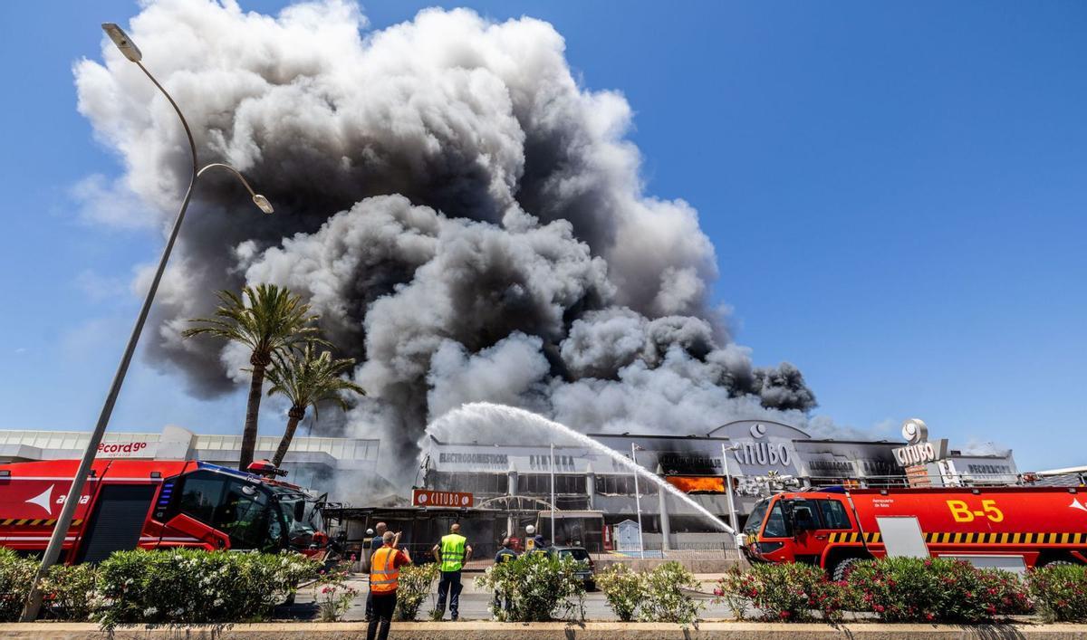 Dos camiones de los bomberos del aeropuerto durante las labores para combatir el incendio de la nave de Citubo. |  | VICENT MARÍ