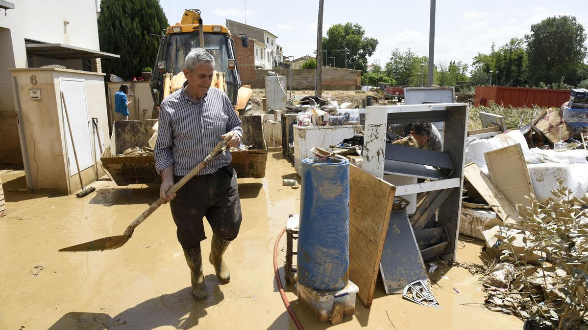 Un vecino de Pomar de Cinca trabaja en la calle para ayudar a quitar los escombros tras las inundaciones