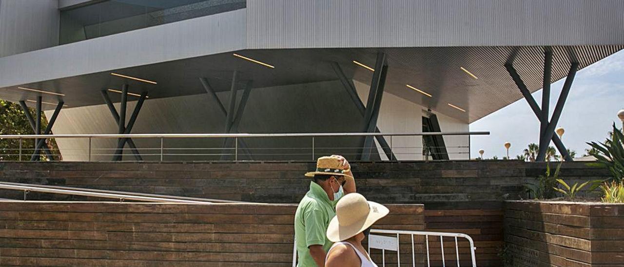 Dos personas pasan frente a la oficina de turismo, aún cerrada.