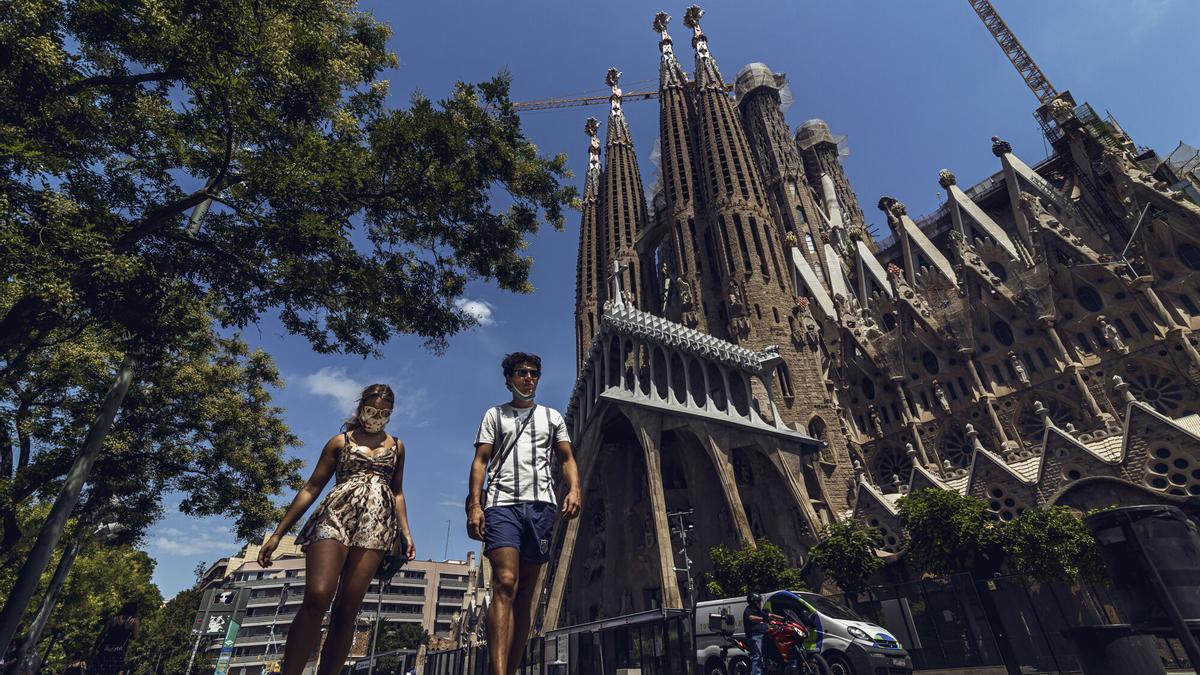 Turistas caminando al lado de la Sagrada Familia.