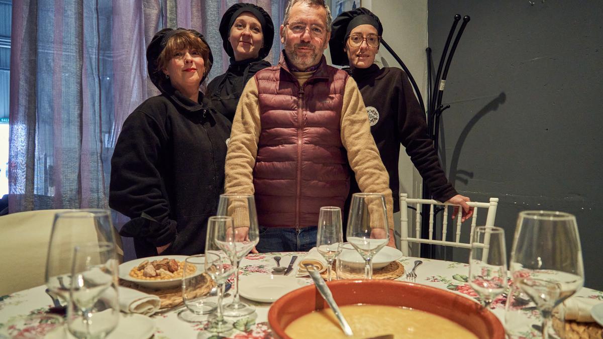Juan Antonio Pajuelo junto a las cocineras de su cátering. En la mesa, un cocido.