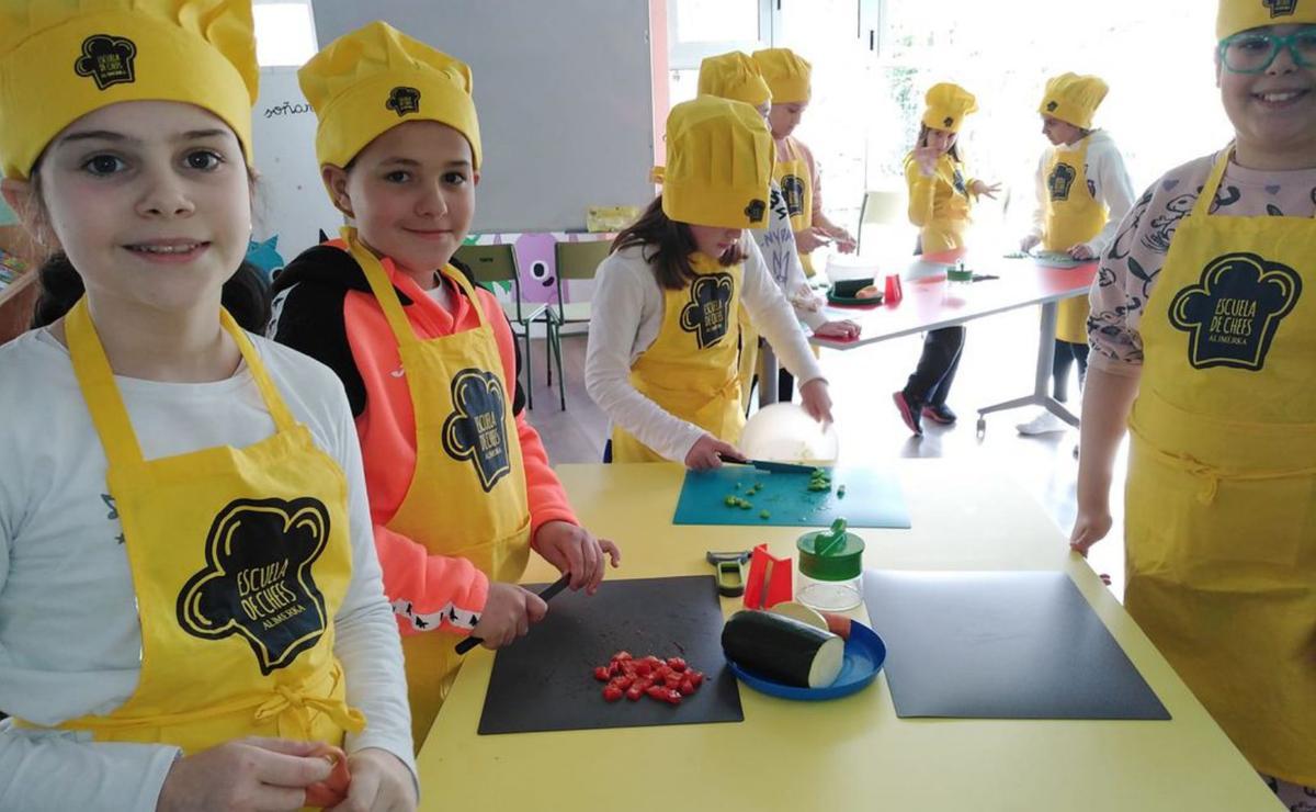 A la manzorga, el programa d’almuerzos escolares. En mediu, el comedor; y a la mandrecha, delles rapacines con xuegos de mesa.