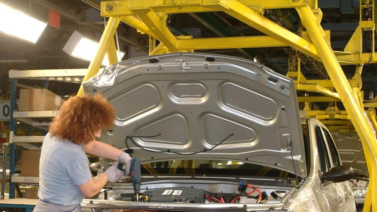 Una mujer, en la cadena de montaje de una fábrica de automóviles