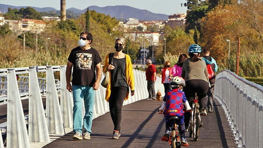 Vianants i ciclistes travessen el nou pont.