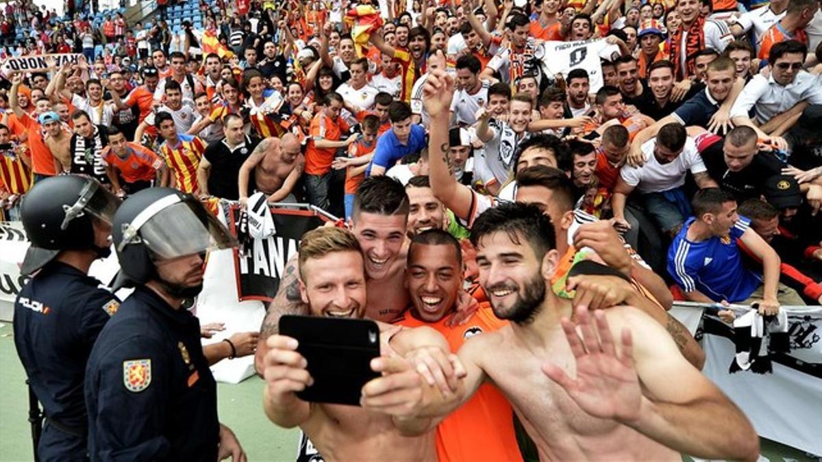 Los jugadores del Valencia se hacen una foto ante su afición tras sellar el pase a la Champions al derrotar al Almería, que se va a Segunda.