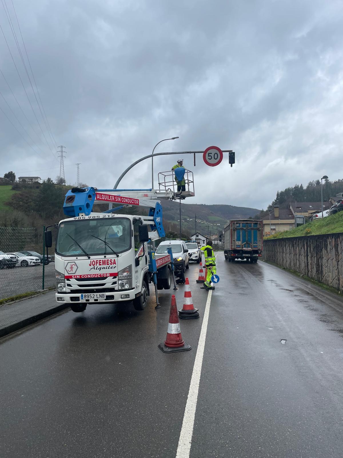 Los operarios trabajando este martes en la renovación del semáforo de preaviso situado a la altura del hospital comarcal Carmen y Servero Ochoa.