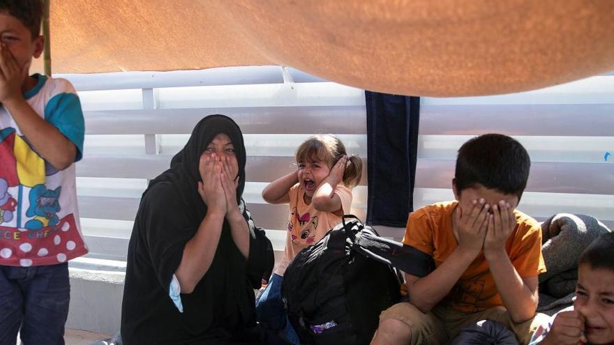 Reacció d&#039;una dona i nens als enfrontaments entre la policia antidisturbis i els refugiats del campament destruït de Moria