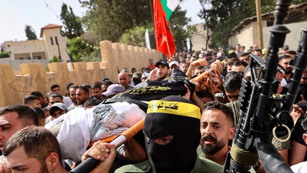 Un grupo de palestinos, algunos de ellos armados, portan el cuerpo de Samih Amarneh, fallecido por las heridas causadas durante los choque con las fuerzas de seguridad israelís en la población de Yaabad, cerca de Yenín.