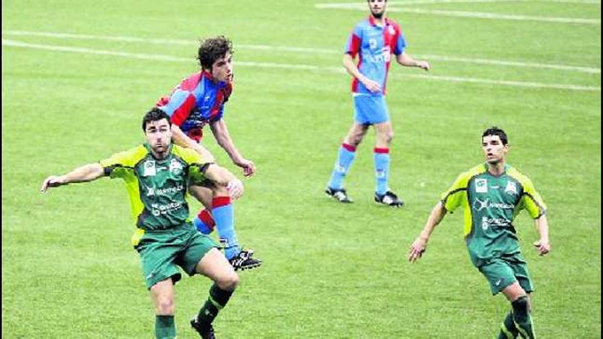 El defensa del Langreo Joaquín se lleva el balón de cabeza ante un jugador del Colloto.