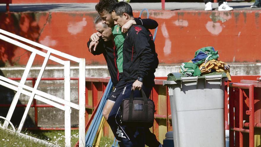 Álex Menéndez toma el camino de los vestuarios apoyado en Jorge Luis y Lobelle tras resultar lesionado.