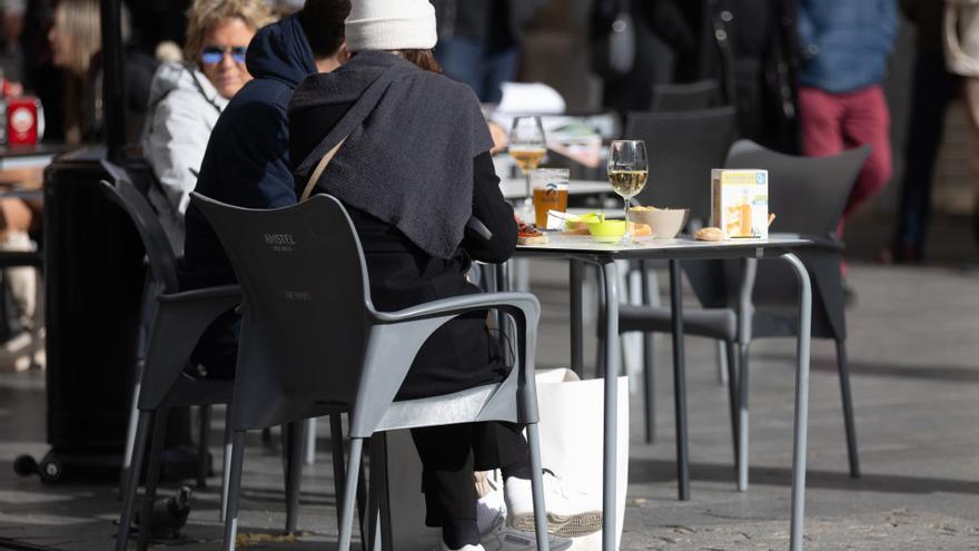 Varias personas en la terraza de una bar.