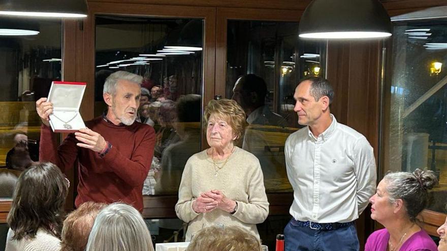 Adolfo Rodríguez muestra la medalla de María Inmaculada que se le regaló a Isabel Barbón, junto a él y a Agustín Estébanez en la cena homenaje.