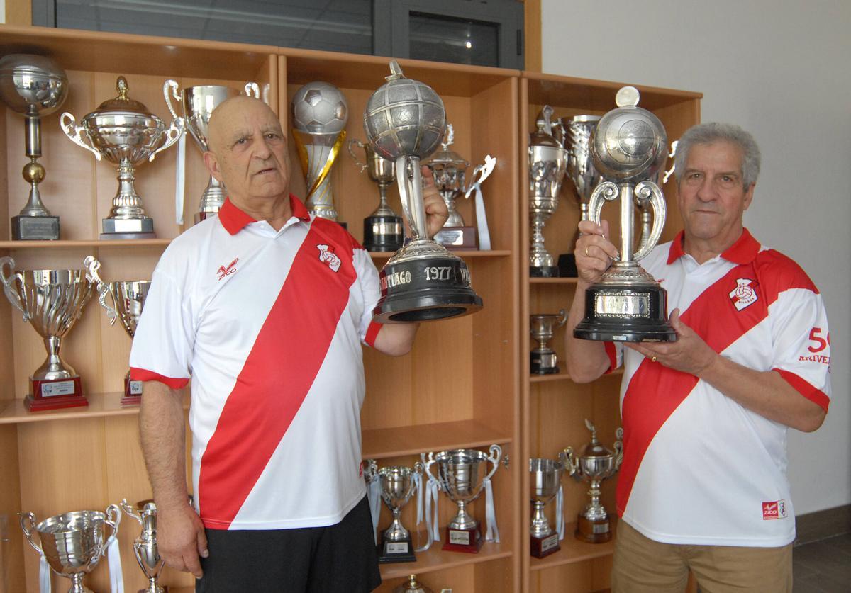 Luis Currás y Darío Brea muestran las Copas do Sar de 1977 y de 1984 conquistadas contra San Mamede y Calo.
