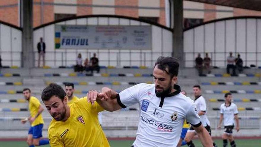 Omar disputa un balón con Quintana.