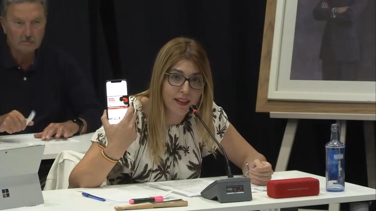 La edil de Cultura de Ribeira, Ana Barreiro (PP) exhibiendo su carné de dorneira en el pleno de este lunes.