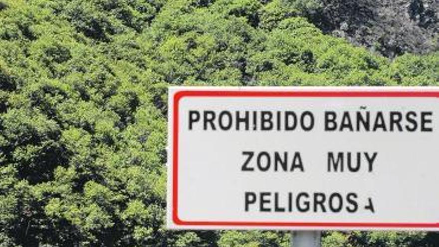 Uno de los carteles que prohíbe el baño en el pantano de Rioseco.