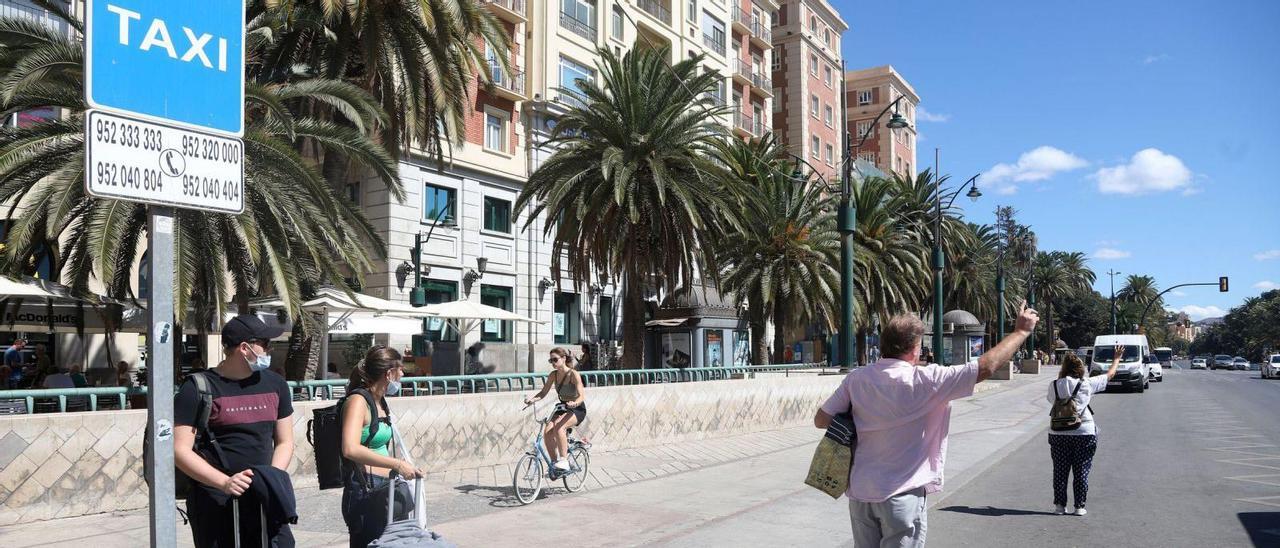 Turistas y locales esperando ayer un taxi en la parada de la plaza de la Marina, en Málaga.