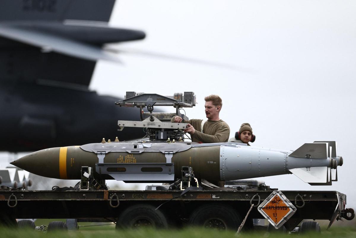 Personal militar de tierra de la USAF prepara municiones de ataque directo conjunto (JDAM) para un bombardero B-1 Lancer de la USAF en la pista de la base aérea de Fairford, en el suroeste de Inglaterra, el 12 de marzo de 2026. Fairford es una de las dos bases, junto con la de Diego García en el Océano Índico, que el Reino Unido ha autorizado a EEUU a utilizar para "operaciones defensivas específicas en Irán" con el fin de destruir misiles iraníes en su origen.