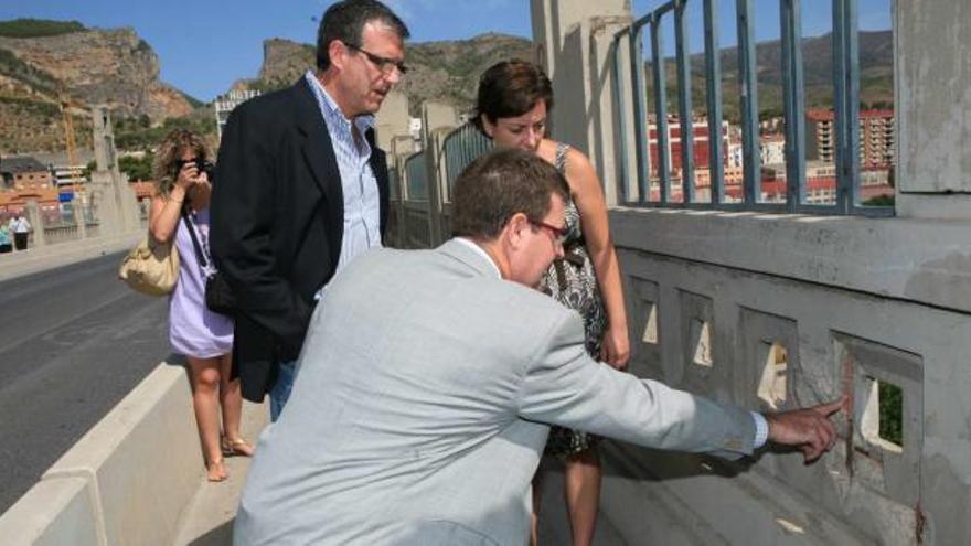 El director general de Urbanismo, el alcalde y la concejala de Urbanismo observan los desperfectos en el puente.