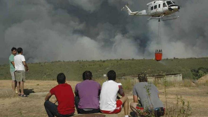 El helicóptero de Medio Ambiente carga agua en Las Torres de Aliste para apagar un fuego en La Culebra.