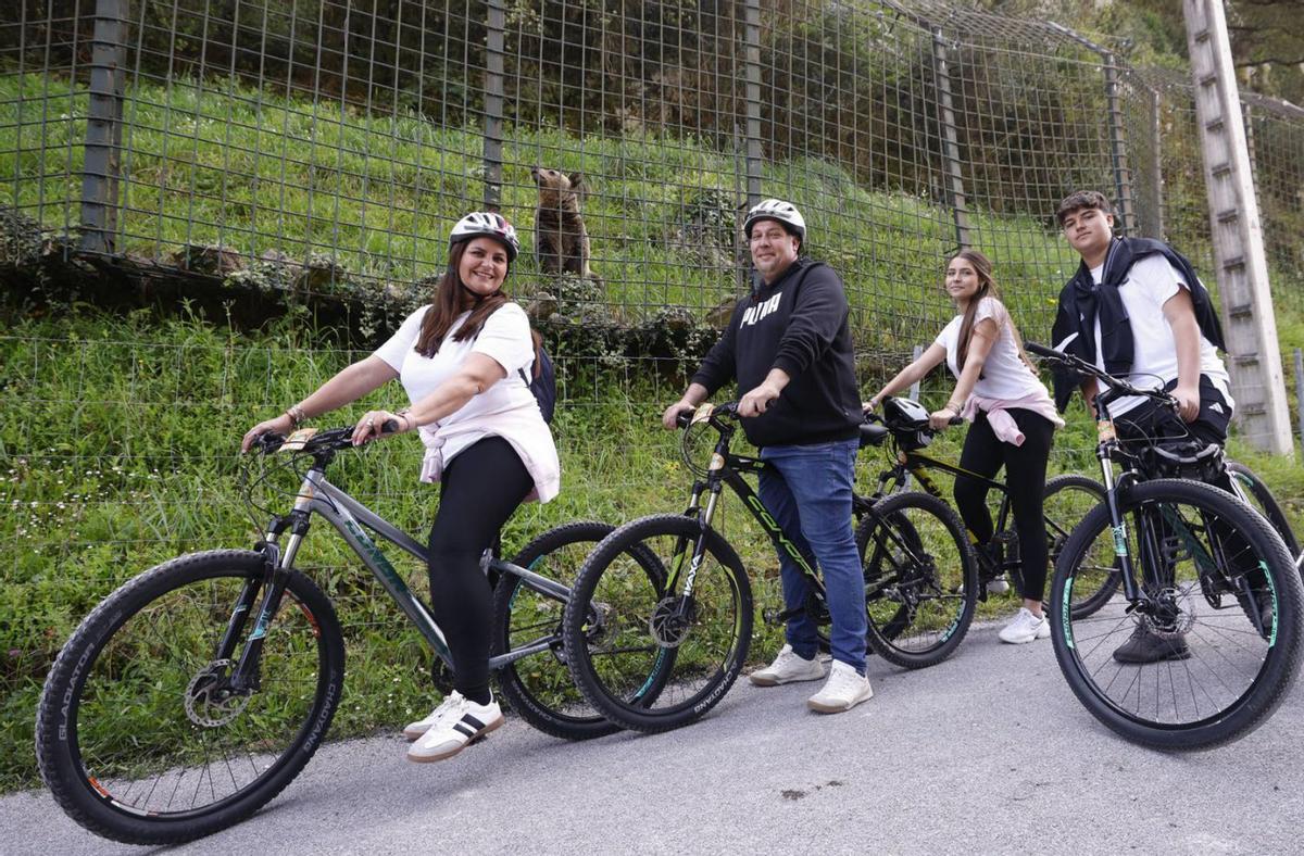 A la izquierda, Sara Lozano, Eugenio Millán, Alba Millán y Eugenio Millán, con «Molinera» detrás. Sobre estas líneas, dos jóvenes hacen fotos con sus móviles al animal. | LUISMA MURIAS