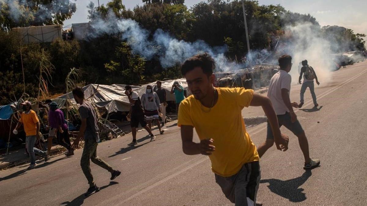 Refugiados de Moria huyen de los gases lacrimógenos lanzados por la policía griega.
