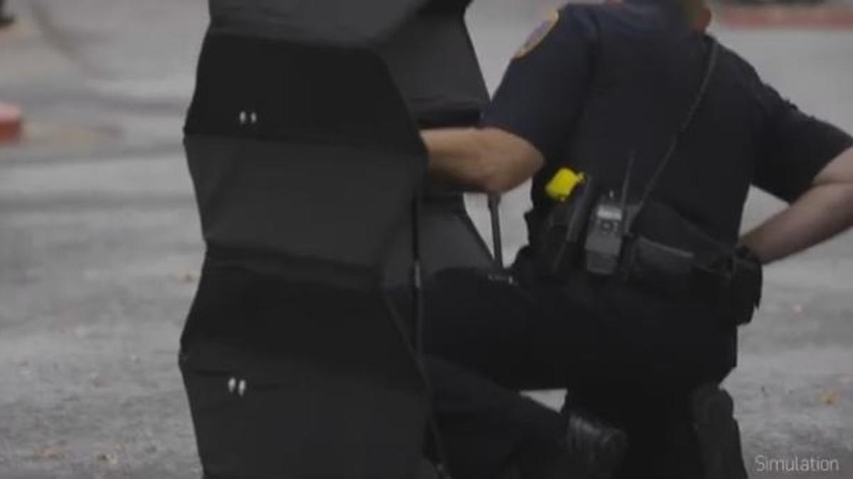 Un agente de policía usa el escudo plegable en una simulación.