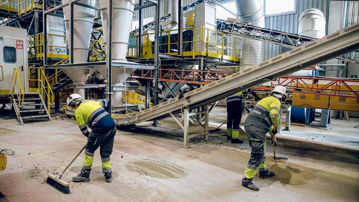 Dos trabajadores en un fábrica de vidrio.
