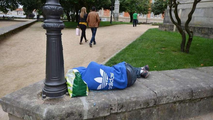 Un joven &quot;sin techo&quot; duerme en un muro de la zona de las Palmeras. // Gustavo Santos