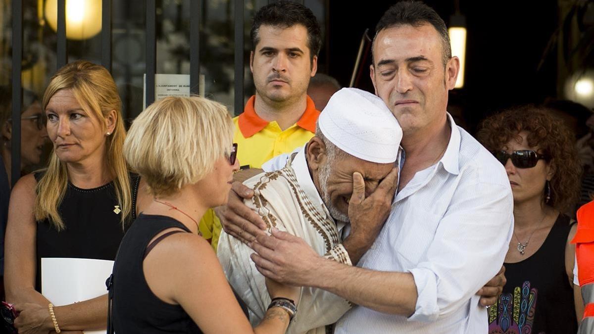 Javier Martinez  padre de Xavi Martinez y Silvia la madre de la victima de tres anos de los atentados de Las Ramblas   emocionados junto al iman suplente